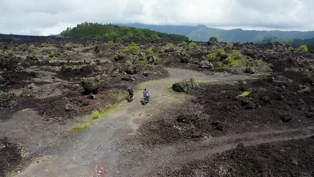 Aerial view of motorbikes on lava fields near Batur volcano Indonesia.