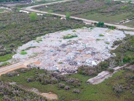 Aerial view of a large landfill site surrounded by rural vegetation and marshy land in Central Seberang Perai Penang Malaysia.
