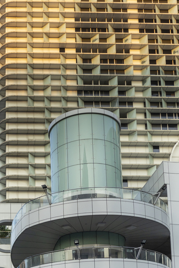 View of modern architectural details featuring a cylindrical glass tower and a grid facade reflecting golden light in Taipei City Taiwan. View of modern architectural details featuring a cylindrical glass tower and a grid facade reflecting golden light in Taipei City Taiwan.