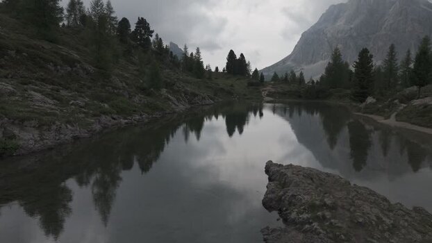 Aerial view of Lago Limides reflecting mountains Italy.