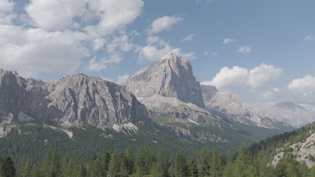 Aerial view of Dolomite mountain peaks and green forests Italy.