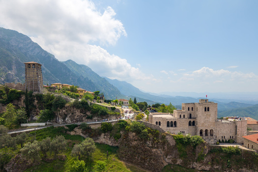 Aerial view of Kruje Castle featuring its historic stone walls clock tower and surrounding mountain landscape under a bright sky Kruje Durres County Albania.