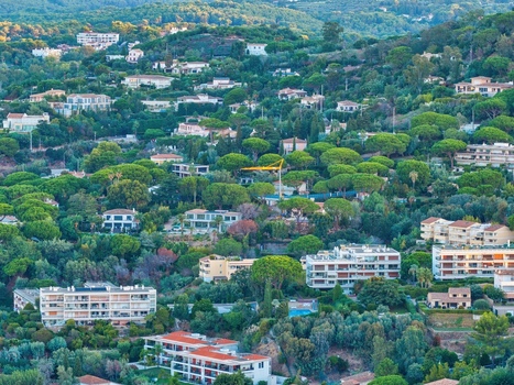 Aerial view of modern residential villas and apartment buildings nestled among lush green pine trees on the hillsides of Cannes Provence Alpes Cote d Azur France. Aerial view of modern residential villas and apartment buildings nestled among lush green pine trees on the hillsides of Cannes Provence Alpes Cote d Azur France.