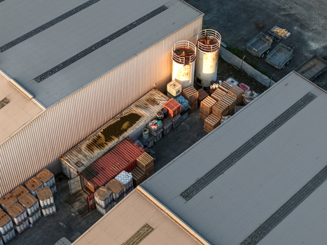 Aerial view of industrial facility in Kilsyth South featuring metal warehouses storage silos and stacks of wooden pallets in the yard Melbourne VIC Australia. Aerial view of industrial facility in Kilsyth South featuring metal warehouses storage silos and stacks of wooden pallets in the yard Melbourne VIC Australia.