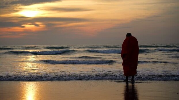 View of a monk standing on the beach at sunset Bangladesh. View of a monk standing on the beach at sunset Bangladesh.