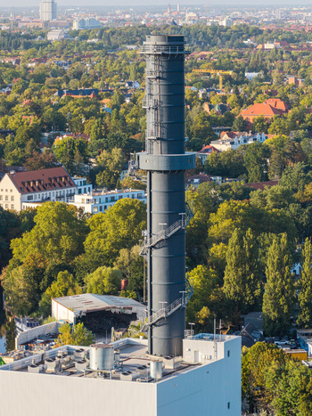 Aerial view of the Combined Heat and Power Plant Lichterfelde chimney rising above the surrounding urban greenery and residential buildings in Berlin Berlin Germany. Aerial view of the Combined Heat and Power Plant Lichterfelde chimney rising above the surrounding urban greenery and residential buildings in Berlin Berlin Germany.