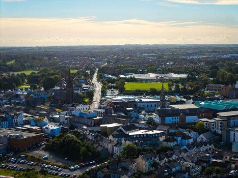 Aerial view of Bangor Harbour and Town with historic buildings residential rooftops and green spaces under a soft sky in Bangor Northern Ireland United Kingdom.