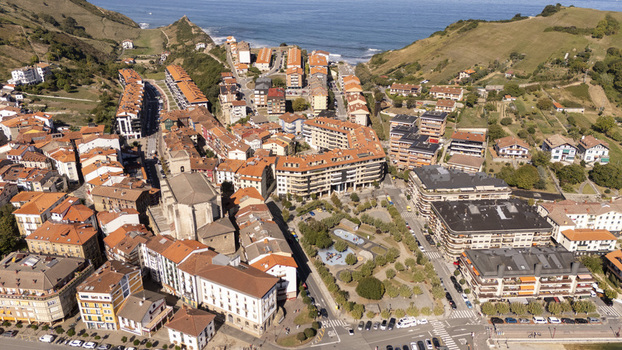 Aerial view of the historic town of Zumaia featuring traditional orange tiled rooftops a central park and coastal hills in Zumaia Basque Country Spain.