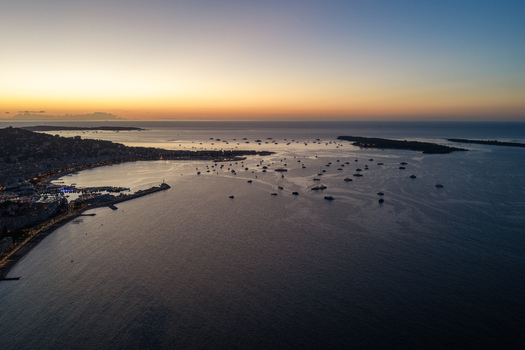 Aerial view of the Bay of Cannes at sunset featuring boats anchored in the water the coastline and the Lerins Islands in the distance Cannes Provence Alpes Cote d Azur France. Aerial view of the Bay of Cannes at sunset featuring boats anchored in the water the coastline and the Lerins Islands in the distance Cannes Provence Alpes Cote d Azur France.
