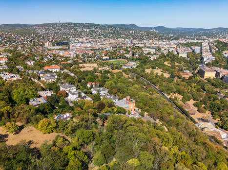 Aerial view of Buda in Budapest Hungary showing tree lined residential neighborhoods urban parks roads and the wooded Buda Hills under a clear summer sky. Aerial view of Buda in Budapest Hungary showing tree lined residential neighborhoods urban parks roads and the wooded Buda Hills under a clear summer sky.