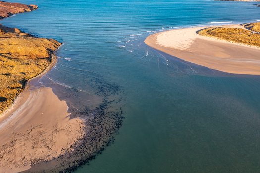 Aerial view of Sheephaven Bay featuring sandy beaches tidal channels and golden coastal dunes under clear light in Dunfanaghy County Donegal Ireland. Aerial view of Sheephaven Bay featuring sandy beaches tidal channels and golden coastal dunes under clear light in Dunfanaghy County Donegal Ireland.