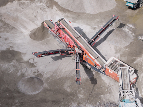 Aerial view of a mobile stone crusher machine processing gravel and sand at a construction site in Krakow Lesser Poland Voivode Poland.