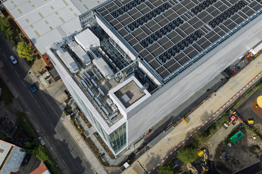 Aerial view of a modern data center with rooftop cooling units and solar panels in the United Kingdom. Aerial view of a modern data center with rooftop cooling units and solar panels in the United Kingdom.