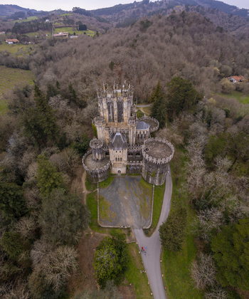 Aerial view of the historic Butron Castle surrounded by dense woodland and lush greenery in Butroi Euskadi Spain. Aerial view of the historic Butron Castle surrounded by dense woodland and lush greenery in Butroi Euskadi Spain.