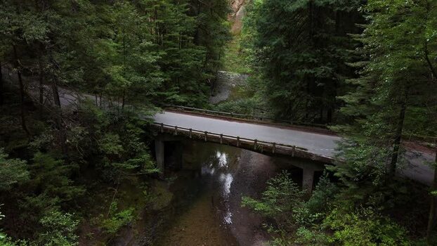 Aerial view of a bridge over a creek in a forest United States. Aerial view of a bridge over a creek in a forest United States.