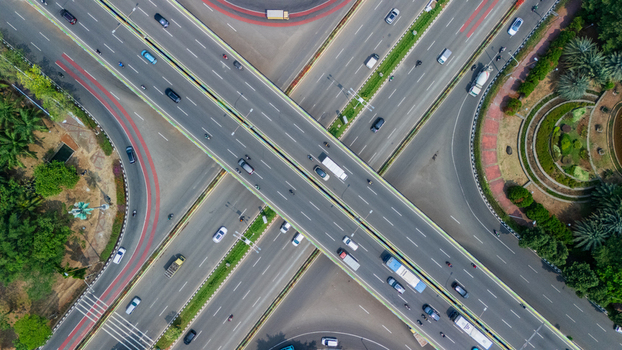 Aerial view of a complex highway interchange with multi level roads flowing traffic and surrounding green landscaping in Jakarta Indonesia. Aerial view of a complex highway interchange with multi level roads flowing traffic and surrounding green landscaping in Jakarta Indonesia.
