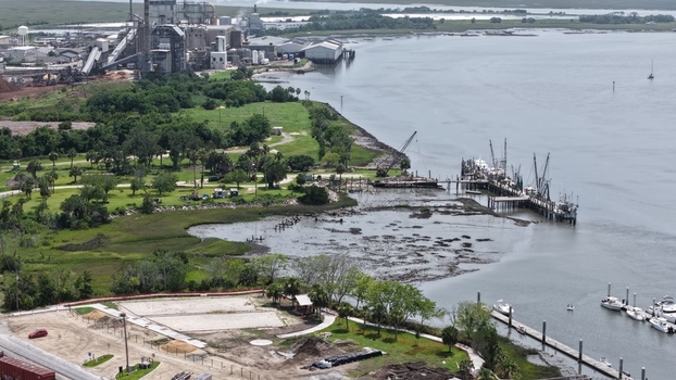 Aerial view of an industrial complex by the water contrasting with vibrant green marshlands a busy pier and a calm marina Fernandina Beach Florida United States. Aerial view of an industrial complex by the water contrasting with vibrant green marshlands a busy pier and a calm marina Fernandina Beach Florida United States.