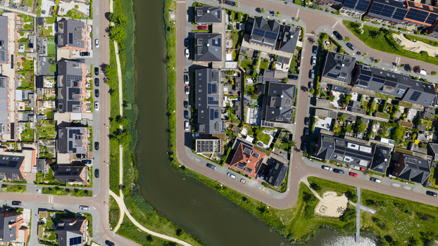 Aerial view of a modern residential neighborhood featuring houses with solar panels a winding canal and green spaces in Utrecht Utrecht Netherlands. Aerial view of a modern residential neighborhood featuring houses with solar panels a winding canal and green spaces in Utrecht Utrecht Netherlands.