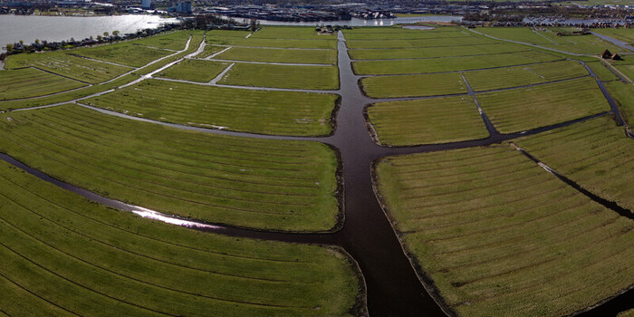 Aerial view of emerald green fields intersected by dark waterways create a striking contrast in the Schaalsmeerpolder Wormer Netherlands. Aerial view of emerald green fields intersected by dark waterways create a striking contrast in the Schaalsmeerpolder Wormer Netherlands.