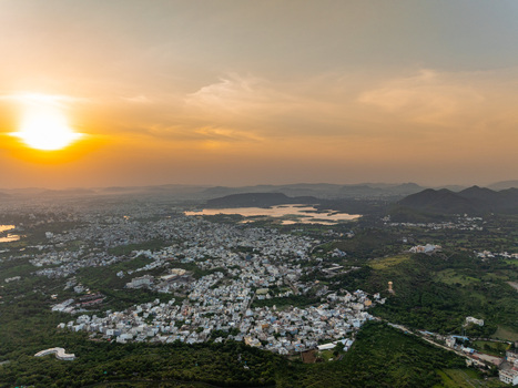 Aerial view of Udaipur city nestled among the Aravalli hills and lakes during a golden sunset in Udaipur Rajasthan India.