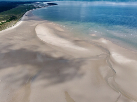 Aerial view of the Moray Firth Coast featuring expansive sandy beaches tidal patterns and clear blue waters in Nairn Scotland United Kingdom.