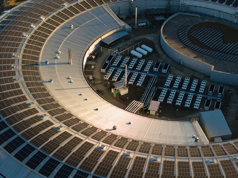 Aerial view of Diamond Light Source a circular synchrotron facility surrounded by greenery under golden hour light in Didcot United Kingdom.