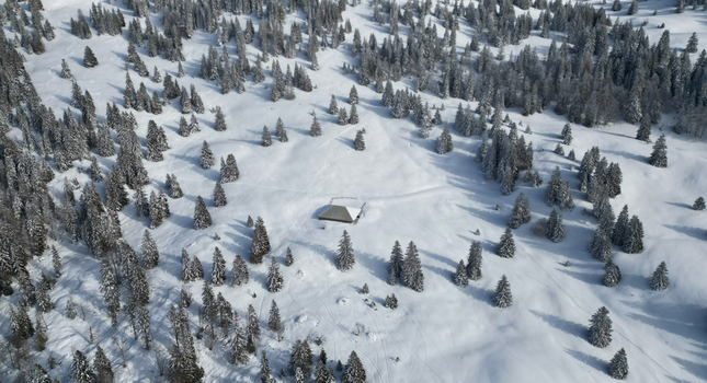 Aerial view of a solitary cabin nestled amid snow laden pines a serene winter tableau Mijoux Auvergne Rhône Alpes France. Aerial view of a solitary cabin nestled amid snow laden pines a serene winter tableau Mijoux Auvergne Rhône Alpes France.