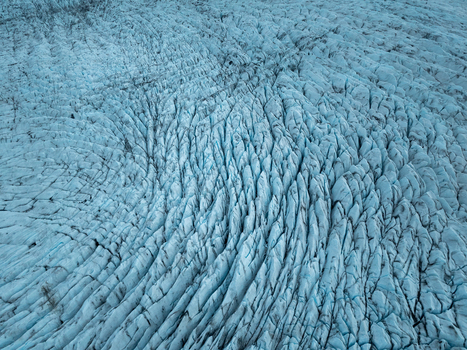 Aerial view of the crevassed surface of Heinabergsjokull glacier showing intricate ice textures and deep blue fissures in Sveitarfelagid Hornafjordur Iceland.