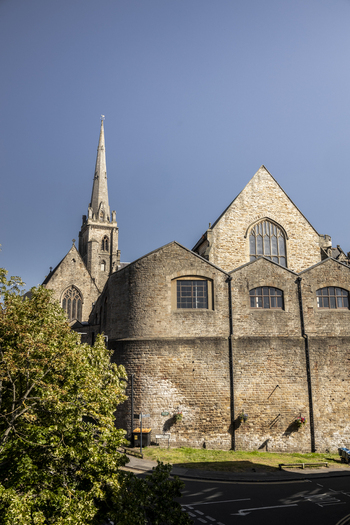 View of the historic stone architecture and tall spire of Durham Cathedral under a clear blue sky in Durham England United Kingdom. View of the historic stone architecture and tall spire of Durham Cathedral under a clear blue sky in Durham England United Kingdom.