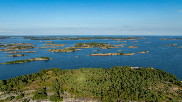 Aerial view of Oro Fortress Island featuring dense pine forests rocky coastlines and the surrounding Baltic Sea archipelago under a clear blue sky in Oro Varsinais Suomi Finland. Aerial view of Oro Fortress Island featuring dense pine forests rocky coastlines and the surrounding Baltic Sea archipelago under a clear blue sky in Oro Varsinais Suomi Finland.