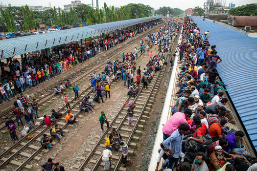 Dhaka Bangladesh 14 June 2018 View of Airport Railway Station with massive crowds of people waiting on platforms and sitting on the roof of a train during the festive rush. Dhaka Bangladesh 14 June 2018 View of Airport Railway Station with massive crowds of people waiting on platforms and sitting on the roof of a train during the festive rush.