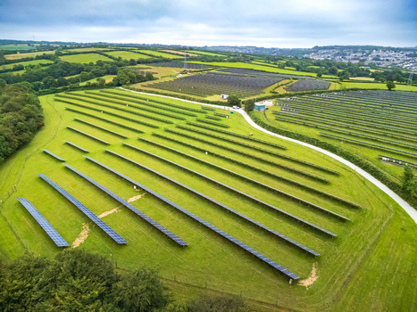 Aerial view of a solar farm with rows of photovoltaic panels set in green fields surrounded by trees and rolling hills in Bodmin Cornwall United Kingdom. Aerial view of a solar farm with rows of photovoltaic panels set in green fields surrounded by trees and rolling hills in Bodmin Cornwall United Kingdom.