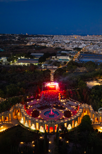 Attard Malta 20 September 2026 Aerial view of Park Nazzjonali Ta Qali at night featuring an illuminated fountain a concert stage with red lighting and a crowd. Attard Malta 20 September 2026 Aerial view of Park Nazzjonali Ta Qali at night featuring an illuminated fountain a concert stage with red lighting and a crowd.