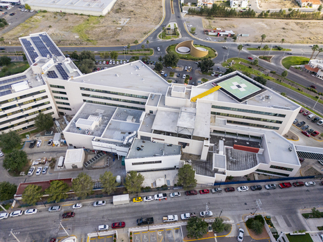 Aerial view of a modern hospital complex with rooftop solar panels a helipad and surrounding urban infrastructure in Chihuahua Chihuahua Mexico. Aerial view of a modern hospital complex with rooftop solar panels a helipad and surrounding urban infrastructure in Chihuahua Chihuahua Mexico.