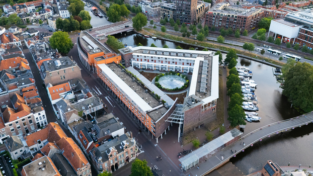 Aerial view of a modern triangular building complex with a central glass dome in the historic city center surrounded by canals and traditional architecture in Zwolle Overijssel Netherlands.