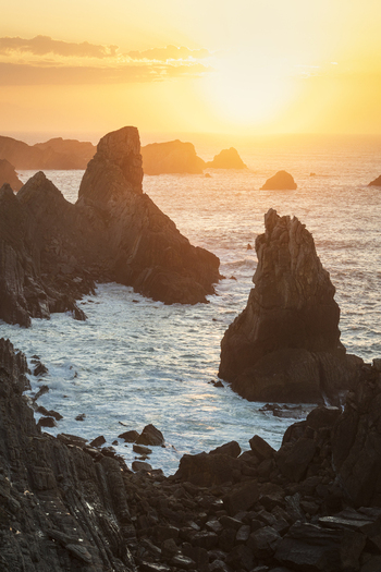View of the dramatic rock formations and sea stacks at sunset along the rugged coastline of Liencres Cantabria Spain. View of the dramatic rock formations and sea stacks at sunset along the rugged coastline of Liencres Cantabria Spain.
