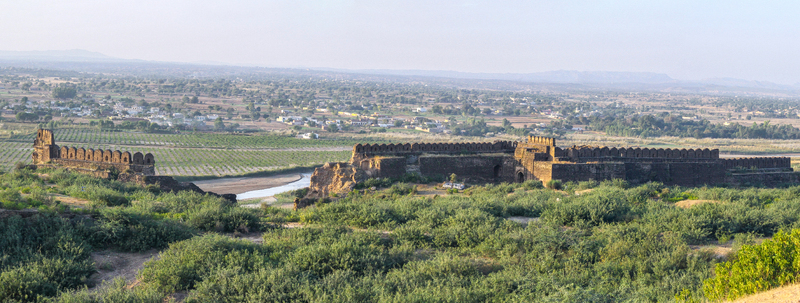 View of Rohtas Fort with its historic stone walls and battlements set against a green landscape and a winding stream in Dina Punjab Pakistan. View of Rohtas Fort with its historic stone walls and battlements set against a green landscape and a winding stream in Dina Punjab Pakistan.