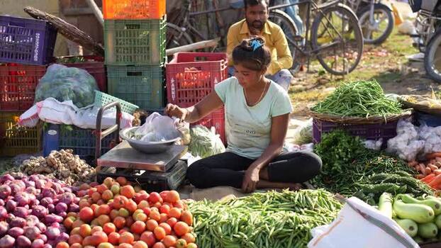 View of a woman selling fresh vegetables at a market Nepal. View of a woman selling fresh vegetables at a market Nepal.