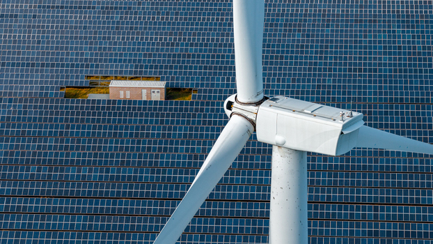 Aerial view of the Chelveston Renewable Energy site featuring a wind turbine and extensive solar panel arrays with a battery energy storage system in Chelveston England United Kingdom. Aerial view of the Chelveston Renewable Energy site featuring a wind turbine and extensive solar panel arrays with a battery energy storage system in Chelveston England United Kingdom.