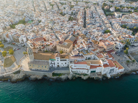 Aerial view of the Church of Sant Bartomeu i Santa Tecla and the historic coastal buildings overlooking the Mediterranean Sea in Sitges Catalonia Spain. Aerial view of the Church of Sant Bartomeu i Santa Tecla and the historic coastal buildings overlooking the Mediterranean Sea in Sitges Catalonia Spain.
