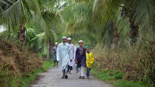 View of people walking on a path lined with palm trees Bangladesh. View of people walking on a path lined with palm trees Bangladesh.