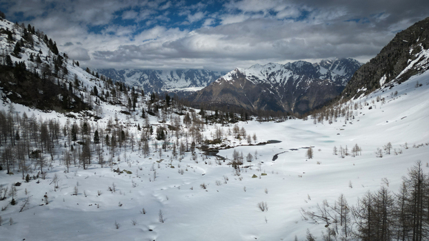 Aerial view of the pristine white snow blankets the valley floor contrasting with the rugged snow capped peaks under a dynamic sky Arpy Valle d Aosta Italy. Aerial view of the pristine white snow blankets the valley floor contrasting with the rugged snow capped peaks under a dynamic sky Arpy Valle d Aosta Italy.