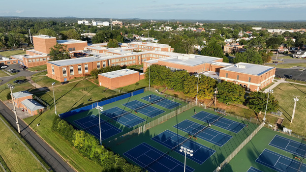 Aerial view of a school campus with red brick buildings and multiple blue tennis courts in Lynchburg Virginia United States.