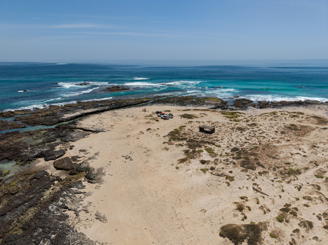 Aerial view of the rugged coastline where turquoise waters meet the sandy shore creating a striking contrast of colors and textures Erissel Socotra Yemen.
