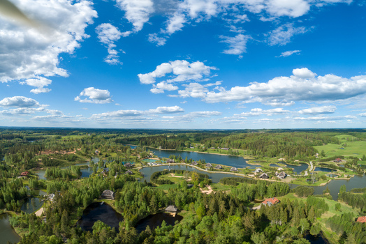 Aerial view of the scenic landscape featuring winding lakes dense forests and scattered wooden houses in Cesis Cesis Municipality Latvia. Aerial view of the scenic landscape featuring winding lakes dense forests and scattered wooden houses in Cesis Cesis Municipality Latvia.