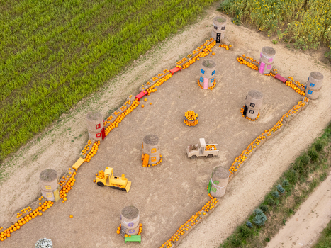 Aerial view of a pumpkin themed display featuring hay bale structures a toy train and a toy truck arranged in a field in Gdansk Poland. Aerial view of a pumpkin themed display featuring hay bale structures a toy train and a toy truck arranged in a field in Gdansk Poland.