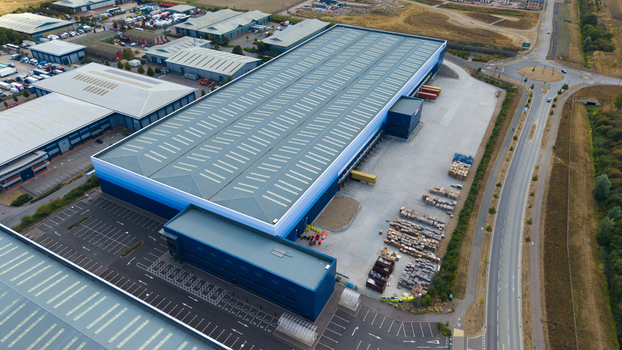 Aerial view of a large logistics hub with industrial warehouses loading docks parked HGVs and surrounding road infrastructure in Bedford England United Kingdom. Aerial view of a large logistics hub with industrial warehouses loading docks parked HGVs and surrounding road infrastructure in Bedford England United Kingdom.