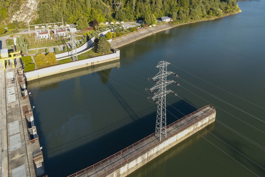 Aerial view of the Niedzica Hydroelectric Power Plant with its concrete dam power transmission towers and calm reservoir water in Niedzica Malopolskie Poland. Aerial view of the Niedzica Hydroelectric Power Plant with its concrete dam power transmission towers and calm reservoir water in Niedzica Malopolskie Poland.