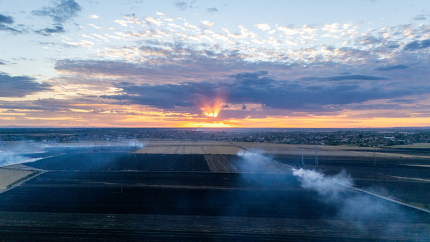 Aerial view of agricultural fields with rising smoke during sunset in Sremska Mitrovica Vojvodina Serbia. Aerial view of agricultural fields with rising smoke during sunset in Sremska Mitrovica Vojvodina Serbia.