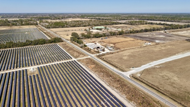 Aerial view of expansive solar panel arrays contrasting against the rural landscape creating a stark juxtaposition of modern energy and rustic charm Elkton Florida United States. Aerial view of expansive solar panel arrays contrasting against the rural landscape creating a stark juxtaposition of modern energy and rustic charm Elkton Florida United States.